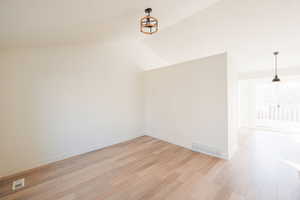 Additional living space featuring lofted ceiling and light wood-type flooring