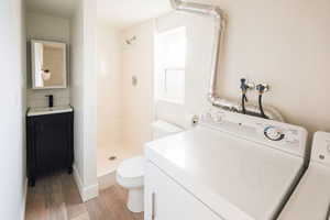 Full bath featuring vanity, a shower stall, and light wood-type flooring