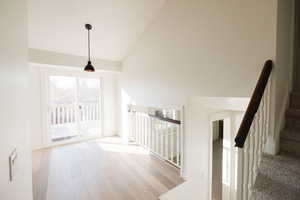 Staircase featuring a high ceiling and wood finished floors