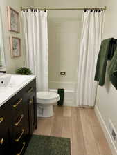 Full bathroom featuring shower / tub combo, light wood-style floors, and vanity