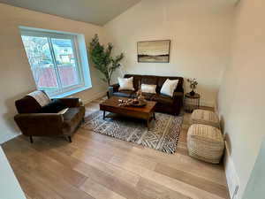 Living room with light wood-style floors and vaulted ceiling