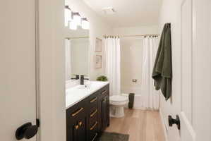 Full bath with vanity, light wood-style floors, and shower / bath combo