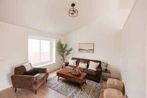 Living room with light wood-type flooring and vaulted ceiling