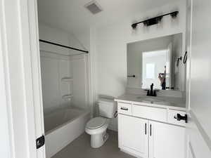 Bathroom with shower / tub combination, vanity, and dark tile patterned floors