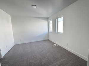 Carpeted spare room featuring baseboards