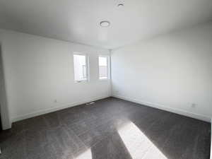 Empty room with dark carpet and baseboards