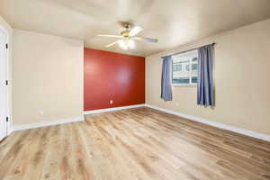 Unfurnished room with light wood-type flooring and ceiling fan