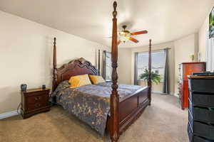 Carpeted bedroom with baseboards and a ceiling fan