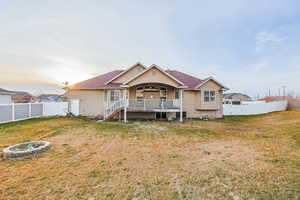 Back of property featuring a fenced backyard, a gate, and a wooden deck