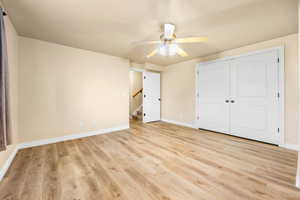 Unfurnished bedroom featuring light wood-style flooring, a ceiling fan, and a closet