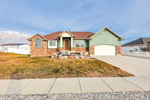 View of front of property featuring board and batten siding, driveway, stone siding, a garage, and a mountain view