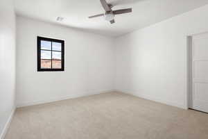 Unfurnished room featuring light colored carpet and a ceiling fan