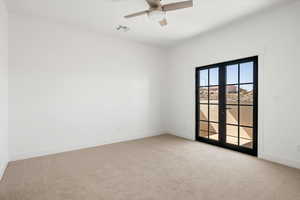 Empty room with light carpet, a ceiling fan, and french doors