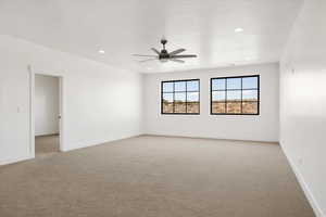 Empty room featuring light colored carpet, ceiling fan, and recessed lighting
