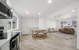 Dining space with light wood-style floors, plenty of natural light, and recessed lighting