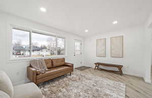 Living area featuring light wood finished floors and recessed lighting