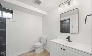 Bathroom with vanity, light wood-style flooring, and a textured ceiling
