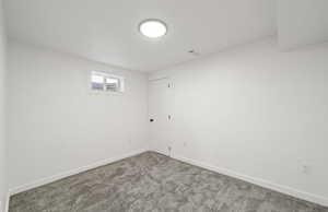 Empty room featuring baseboards and carpet flooring