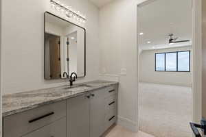 Bathroom with vanity, recessed lighting, light colored carpet, and a ceiling fan