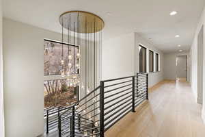 Top of the stairs featuring the second level of the chandelier.