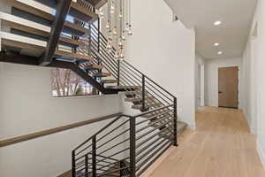 Stairs with wood-type flooring and recessed lighting