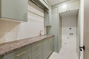 Laundry area featuring cabinet space, washer hookup, electric dryer hookup, and light tile patterned floors