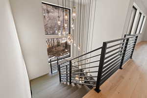 Stairs featuring hardwood / wood-style floors and suspended lighting