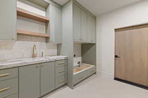 Laundry room featuring cabinet space, light tile patterned floors, and electric dryer hookup