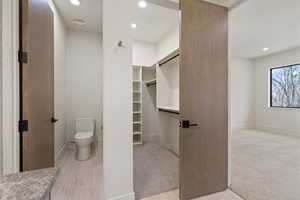 Bathroom featuring recessed lighting, light wood-style flooring, and a spacious closet