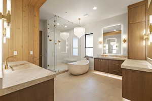 Primary Bath with steam shower, with 2 shower heads + rainfall shower head and  artisan plaster walls, Taj Mahal  quartzite integrated sinks, free standing solid marble tub, and make up station.