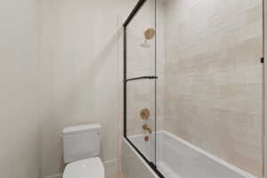 Bathroom with enclosed tub / shower combo and toilet