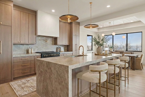 Kitchen featuring decorative light fixtures, a kitchen breakfast bar, tasteful backsplash, light wood finished floors, and light stone countertops