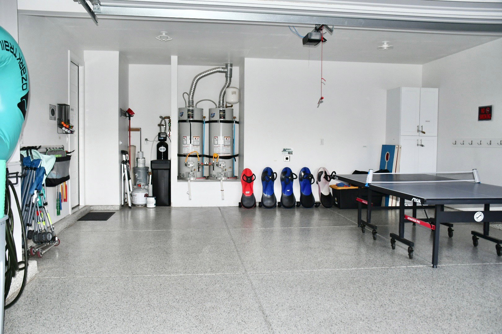 Garage with strapped water heater and a garage door opener