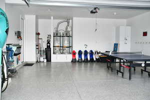 Garage with strapped water heater and a garage door opener