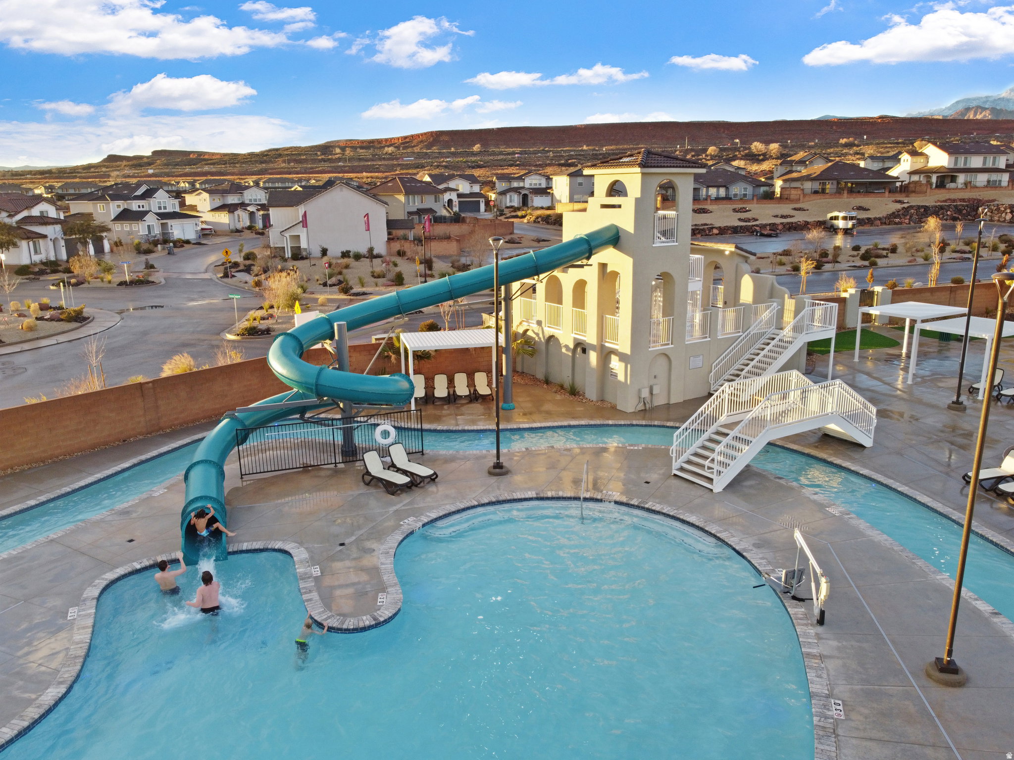 Community pool featuring a water slide, a water play area, a mountain view, a residential view, and a patio