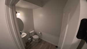 Half bath featuring baseboards and light wood finished floors