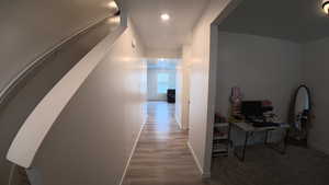 Hallway with baseboards and light wood-style flooring