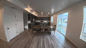 Dining area featuring dark wood-type flooring and recessed lighting
