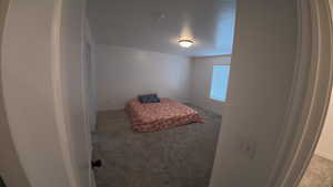 Carpeted bedroom featuring baseboards and a textured ceiling