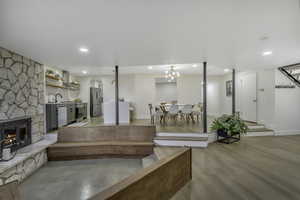 Living room featuring a stone fireplace and recessed lighting