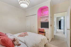 Carpeted bedroom with a chandelier and a closet