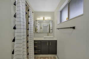 Bathroom with vanity and curtained shower
