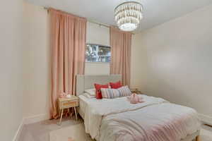 Bedroom with a chandelier and carpet