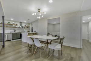 Dining room featuring light wood-type flooring, a chandelier, and recessed lighting