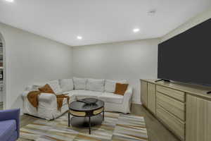 Living room featuring recessed lighting, light wood-style flooring, and arched walkways