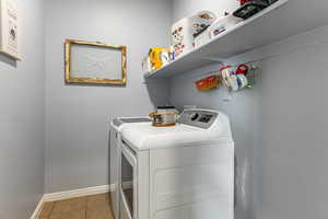 Laundry room featuring light tile patterned floors and independent washer and dryer