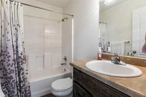 Full bath featuring shower / bath combination with curtain and vanity