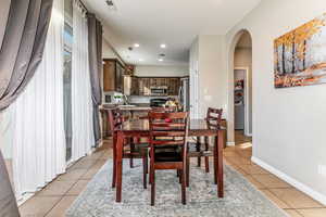 Dining room with arched walkways, recessed lighting, washer / clothes dryer, and light tile patterned floors