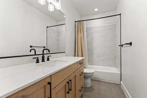 Bathroom featuring shower / tub combo with curtain, vanity, light tile patterned floors, and recessed lighting
