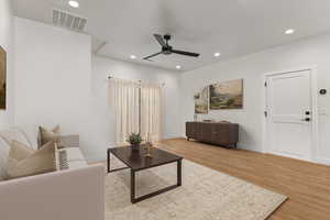 Living area featuring light wood-type flooring, ceiling fan, and recessed lighting